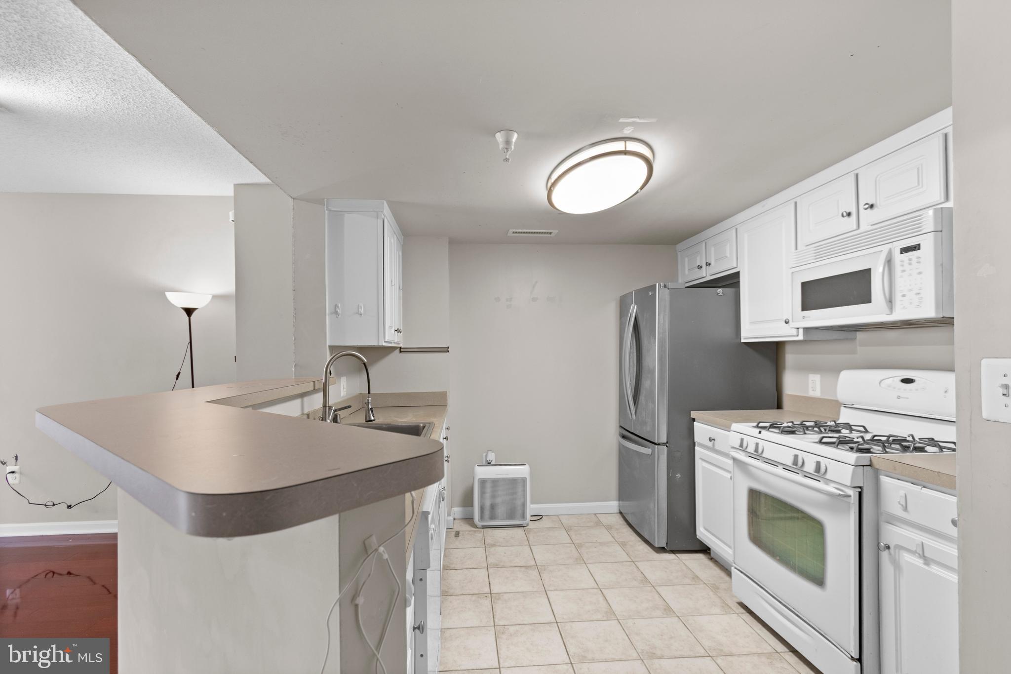 11710 Old Georgetown Road, Unit 1007 North Bethesda, MD 20852 - Photo 12 of 30 a kitchen with stainless steel appliances a sink stove and refrigerator