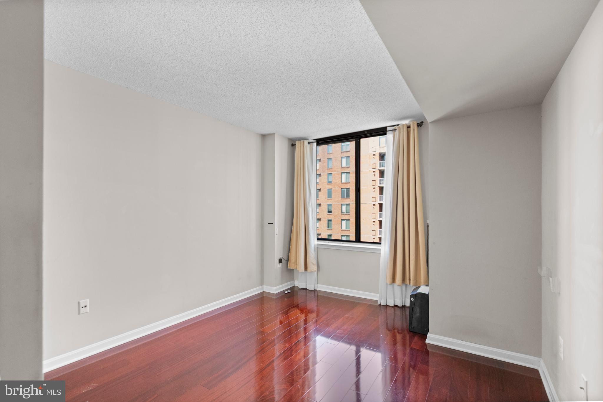 11710 Old Georgetown Road, Unit 1007 North Bethesda, MD 20852 - Photo 16 of 30 an empty room with wooden floor and windows
