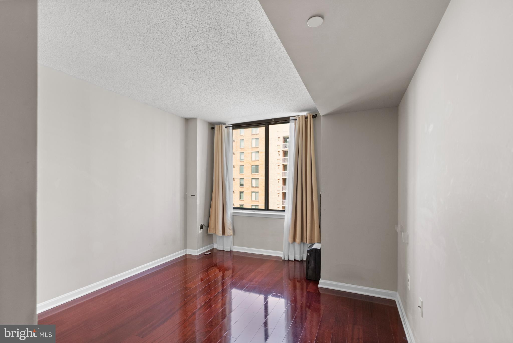 11710 Old Georgetown Road, Unit 1007 North Bethesda, MD 20852 - Photo 20 of 30 an empty room with wooden floor and windows