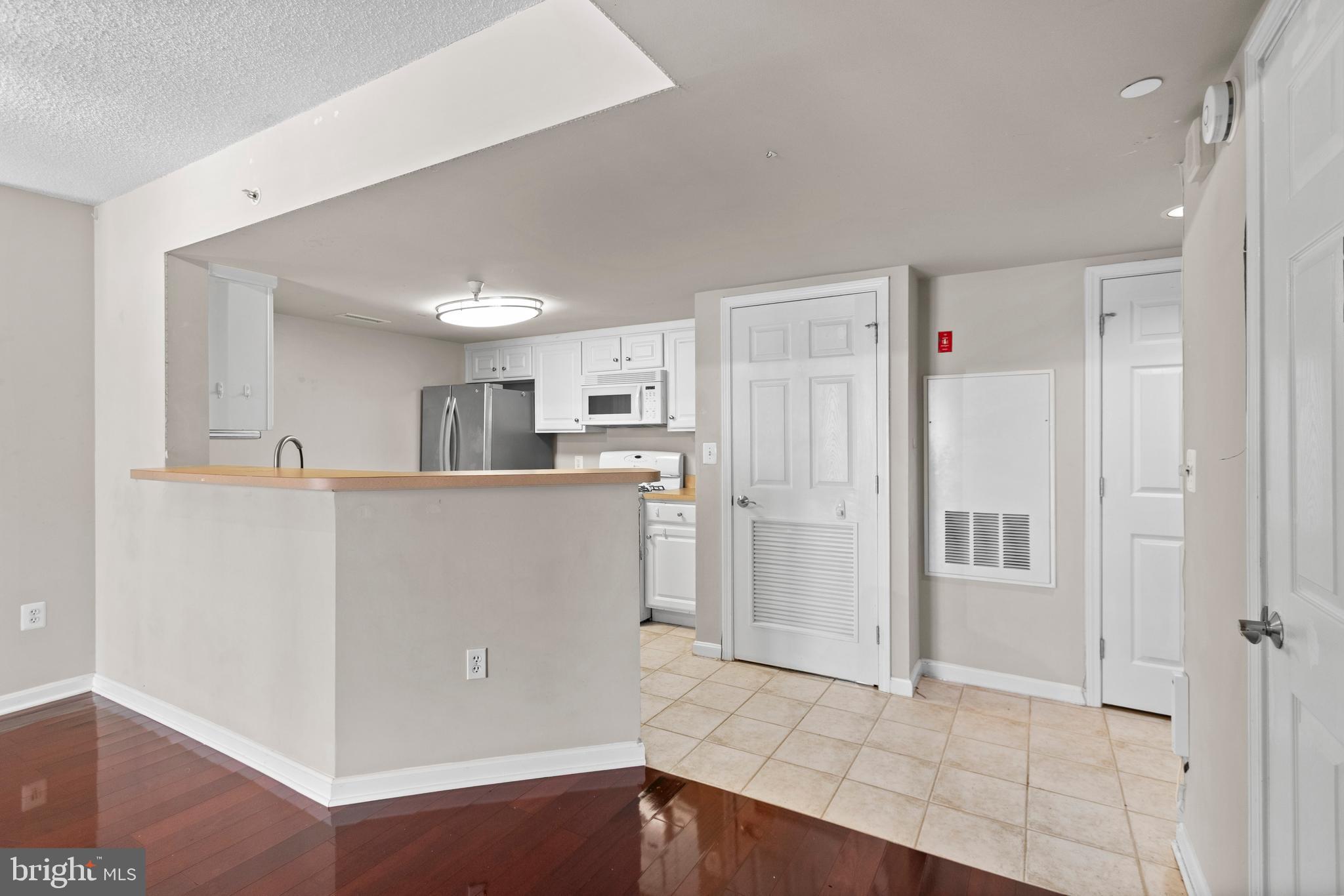 11710 Old Georgetown Road, Unit 1007 North Bethesda, MD 20852 - Photo 22 of 30 a view of a kitchen with refrigerator and white cabinets