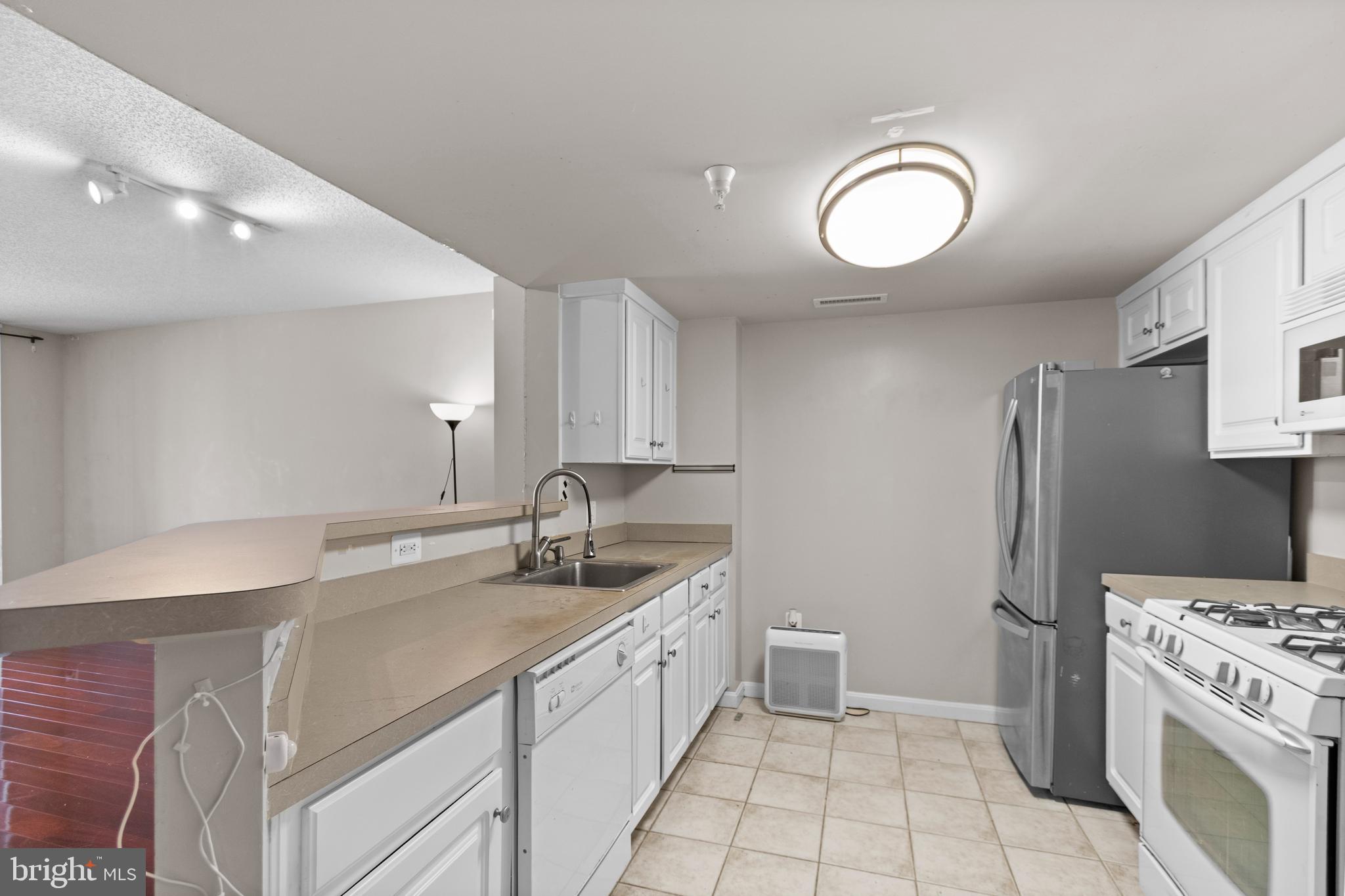 11710 Old Georgetown Road, Unit 1007 North Bethesda, MD 20852 - Photo 10 of 30 a kitchen with a sink cabinets and stainless steel appliances