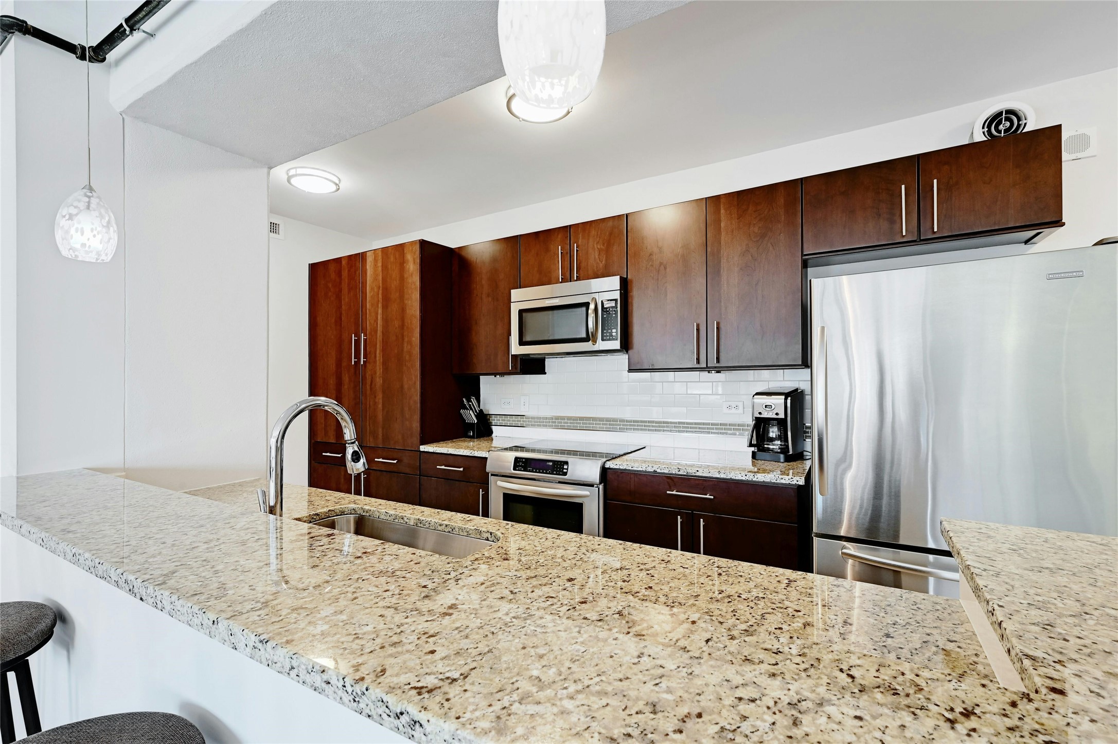 800 Brazos Street, Unit 705 Austin, TX 78701 - Photo 11 of 33 a kitchen with stainless steel appliances granite countertop a refrigerator and a stove top oven