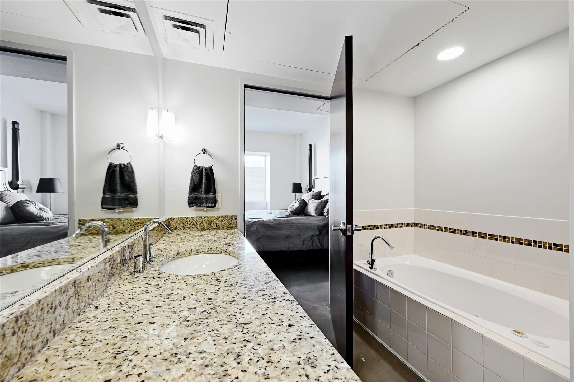800 Brazos Street, Unit 705 Austin, TX 78701 - Photo 18 of 33 a en suite bathroom with a granite countertop tub and a large mirror