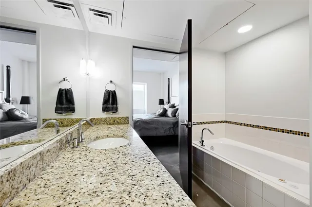 a bathroom with a granite countertop shower sink and mirror