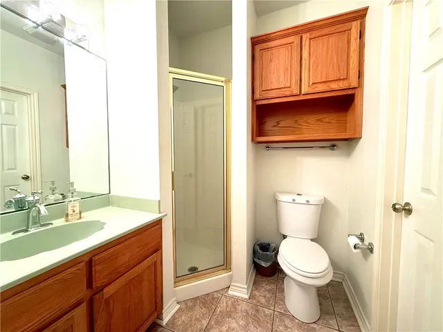 a bathroom with a granite countertop toilet sink and mirror