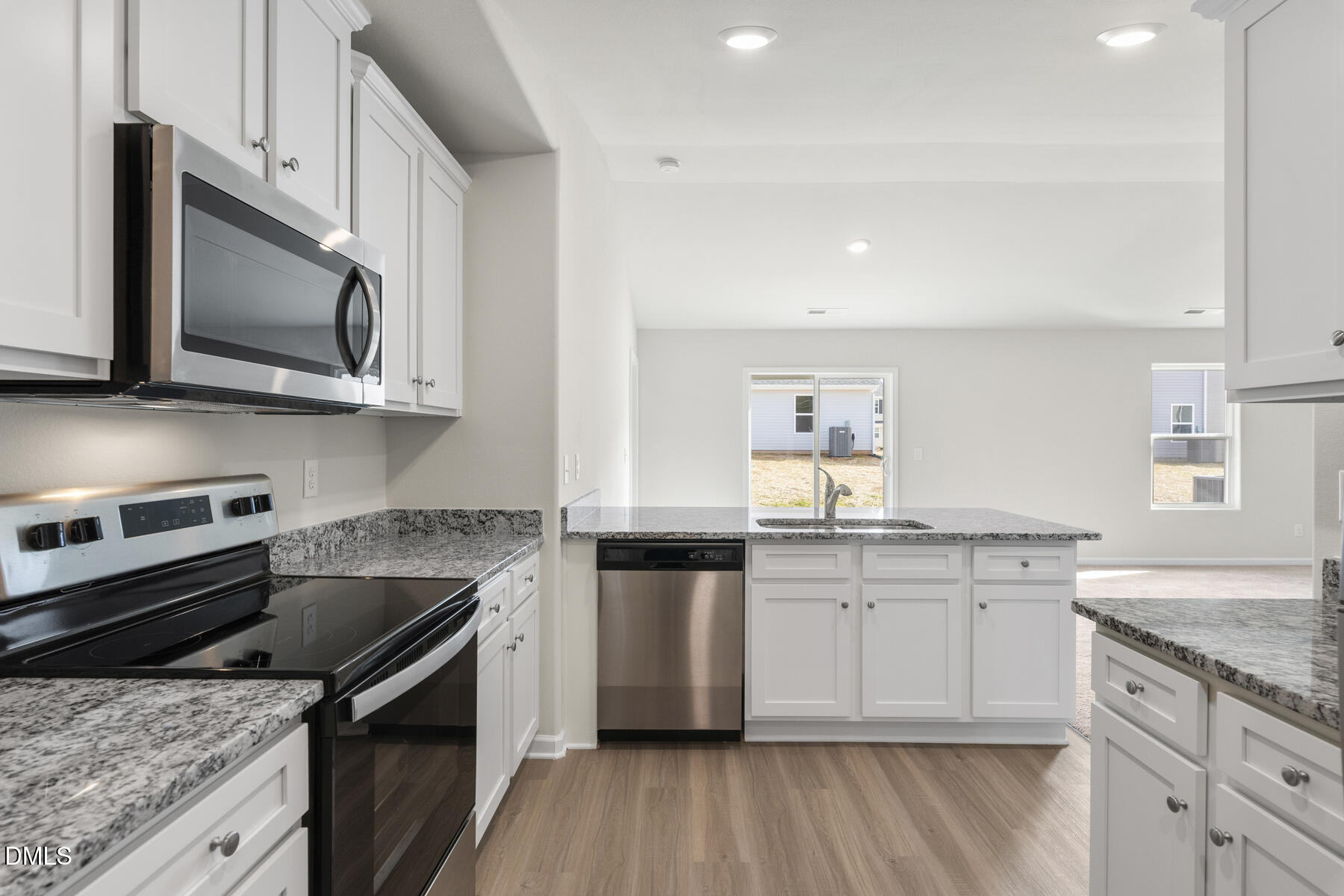 12 Crow Field Street Roxboro, NC 27574 - Photo 5 of 9 a kitchen with stainless steel appliances granite countertop a stove top oven a sink dishwasher and microwave oven with wooden floor