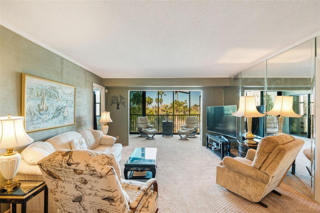 5855 Midnight Pass Road, Unit 318 Sarasota, FL 34242 - Photo 11 of 40 a living room with furniture ceiling fan and a floor to ceiling window