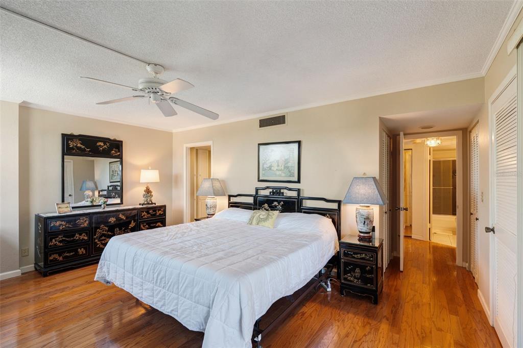 5855 Midnight Pass Road, Unit 318 Sarasota, FL 34242 - Photo 14 of 40 a large bedroom with a bed and wooden floor