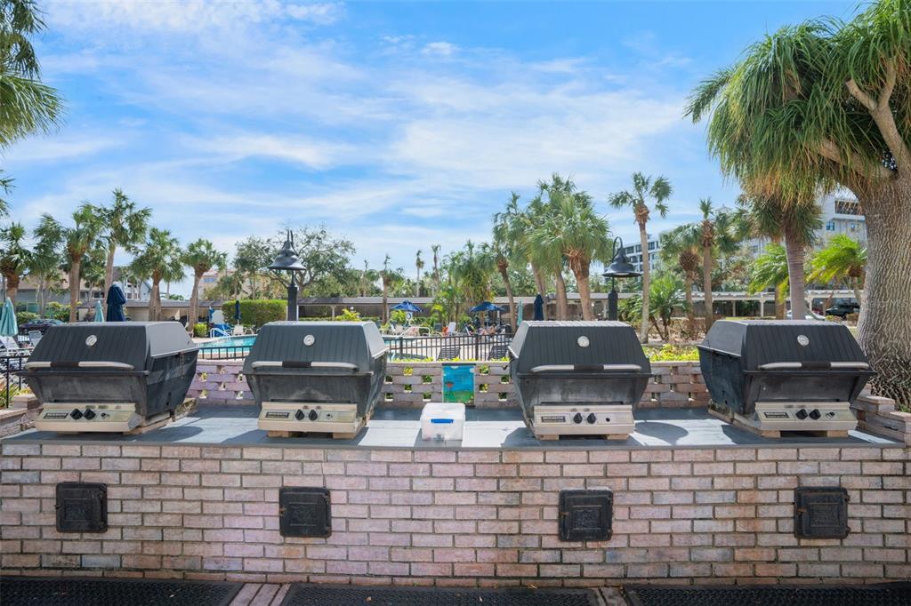 5855 Midnight Pass Road, Unit 318 Sarasota, FL 34242 - Photo 28 of 40 a view of a lake with a barbeque and wooden stairs