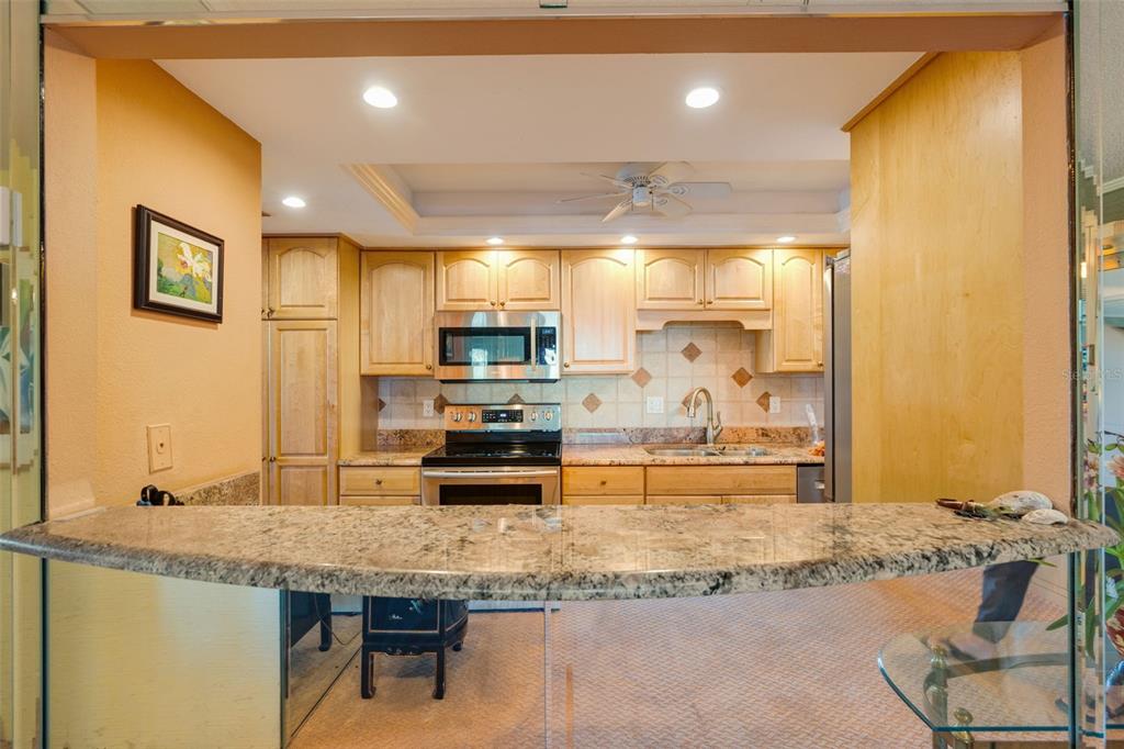 5855 Midnight Pass Road, Unit 318 Sarasota, FL 34242 - Photo 4 of 40 a kitchen with stainless steel appliances granite countertop a sink and cabinets