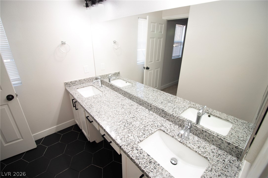1468 Reef Ridge Court Las Vegas, NV 89128 - Photo 19 of 22 Double vanity with stone counters provides ample space and sleek design in this bathroom.
