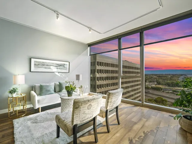 a living room with furniture and a floor to ceiling window