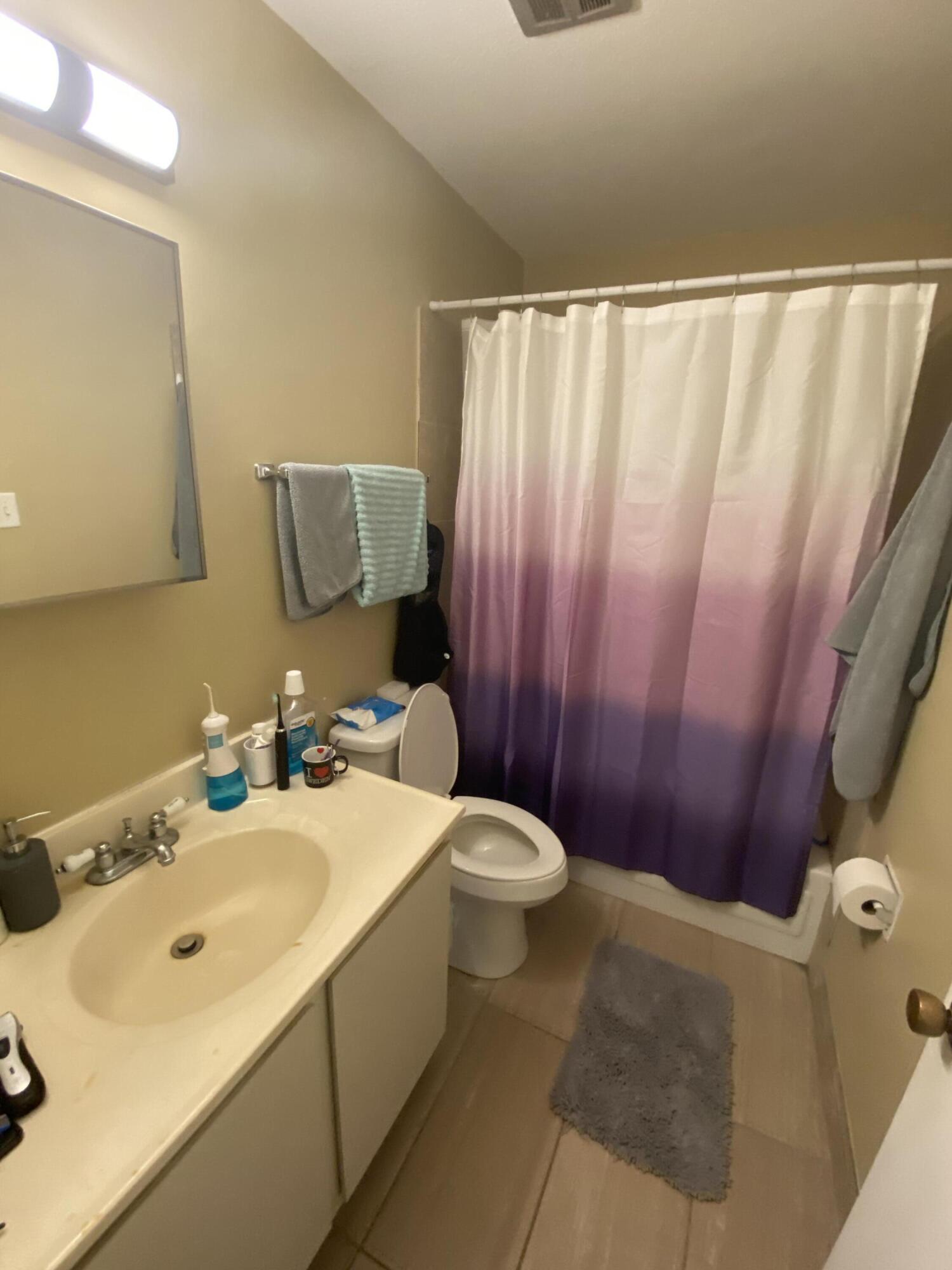 210 Pelham Road, Unit 213A Fort Walton Beach, FL 32547 - Photo 12 of 16 a bathroom with a sink a toilet and mirror