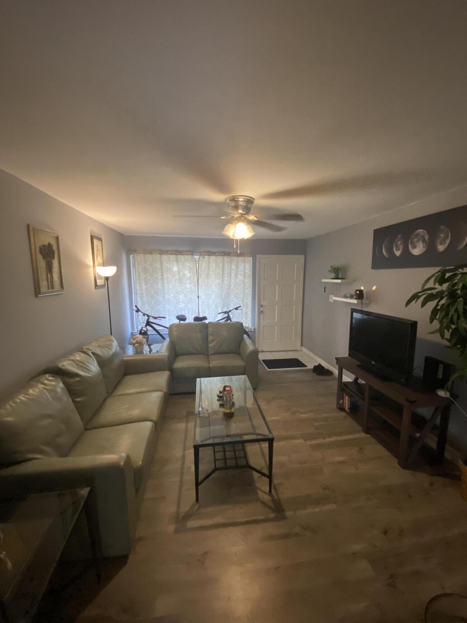 210 Pelham Road, Unit 213A Fort Walton Beach, FL 32547 - Photo 3 of 16 a living room with furniture and a flat screen tv