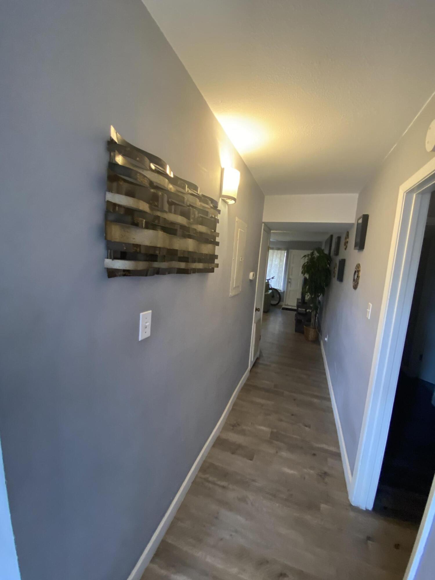 210 Pelham Road, Unit 213A Fort Walton Beach, FL 32547 - Photo 8 of 16 a view of a hallway with wooden floor and stairs