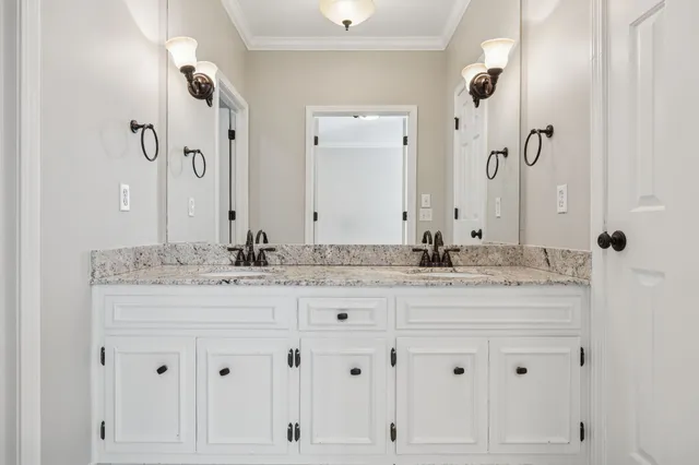 a bathroom with white cabinets and a sink