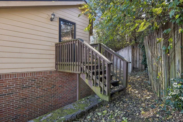 a view of a pathway with a small yard and wooden fence