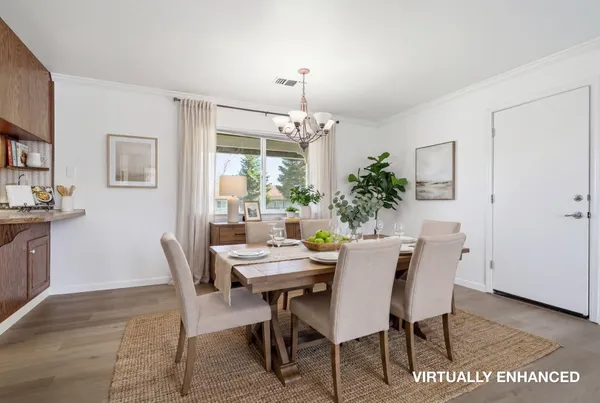 a dining room with furniture potted plants and wooden floor