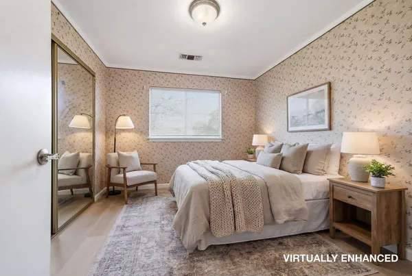 a bedroom with a bed and wooden floor