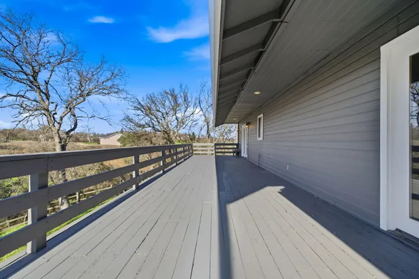 a view of a balcony with wooden floor and fence