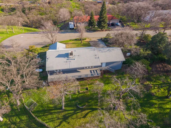 an aerial view of a house with a yard swimming pool and outdoor seating
