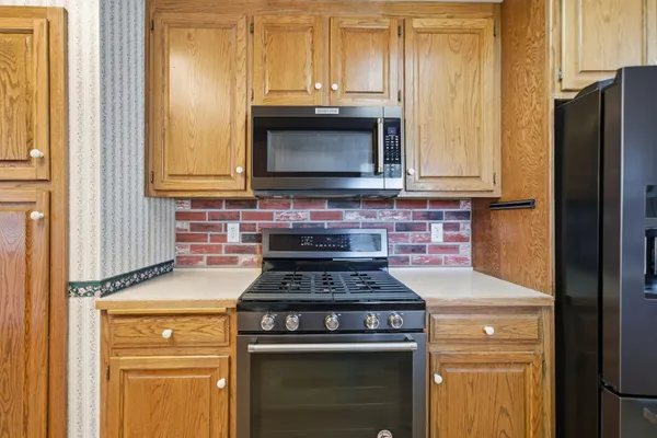 a kitchen with granite countertop a stove and a microwave