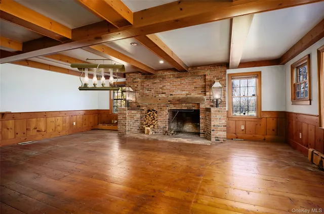 a view of empty room with wooden floor and fireplace