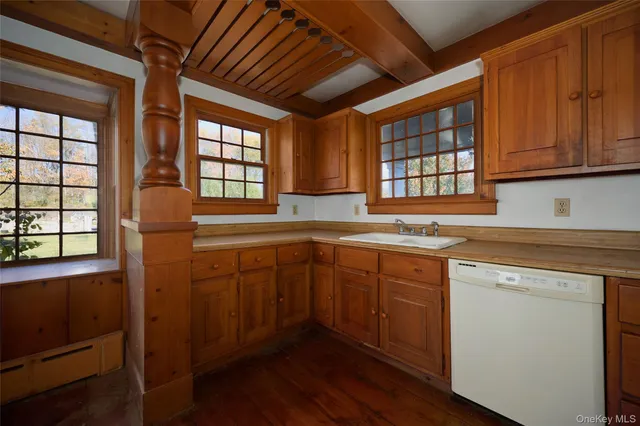 a kitchen with stainless steel appliances granite countertop wooden cabinets sink and window