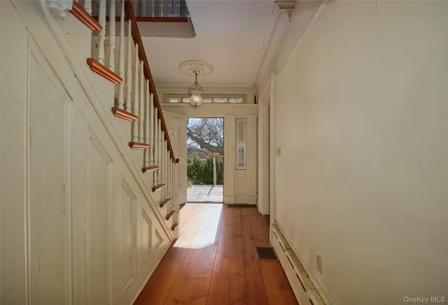 a view of a hallway with wooden floor and staircase