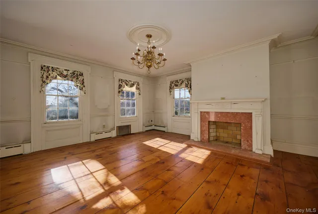 an empty room with windows fireplace and windows