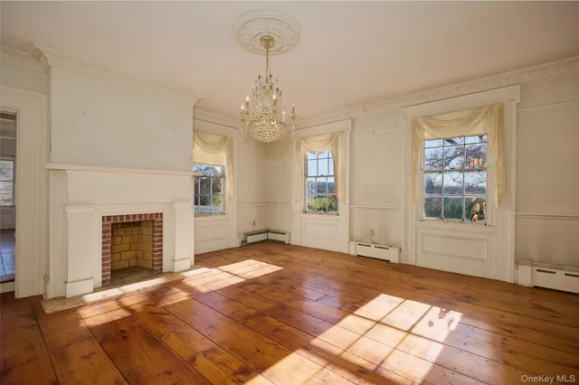 a view of an empty room with window and fire place