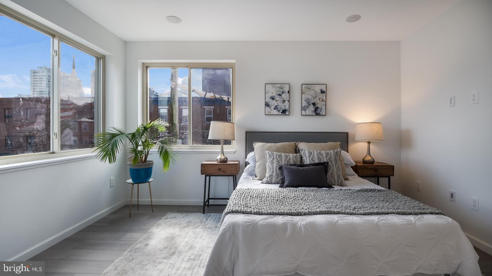1825 Callowhill Street, Unit 311 Philadelphia, PA 19130 - Photo 22 of 50 a bedroom with a large bed and a potted plant