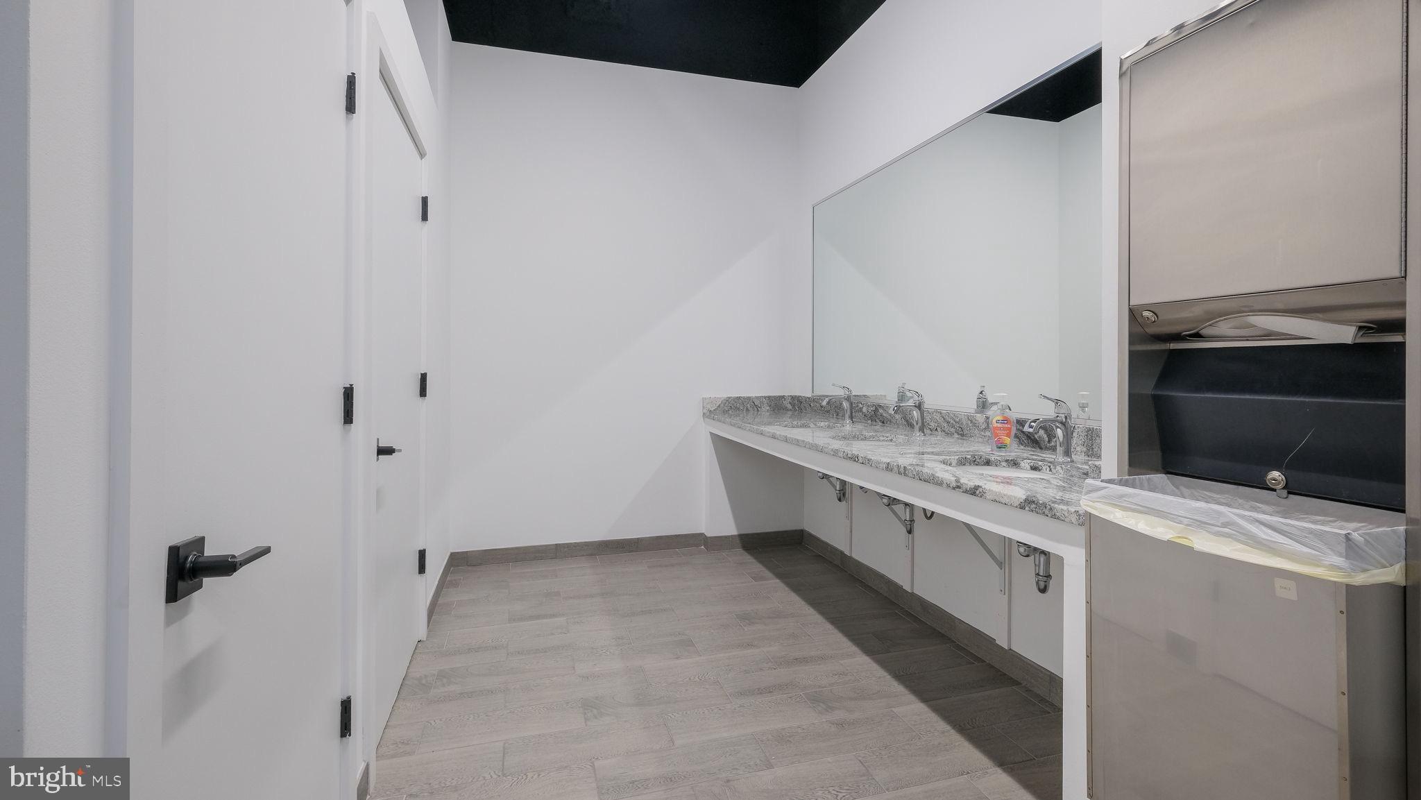 1825 Callowhill Street, Unit 311 Philadelphia, PA 19130 - Photo 48 of 50 a bathroom with a granite countertop sink and a mirror