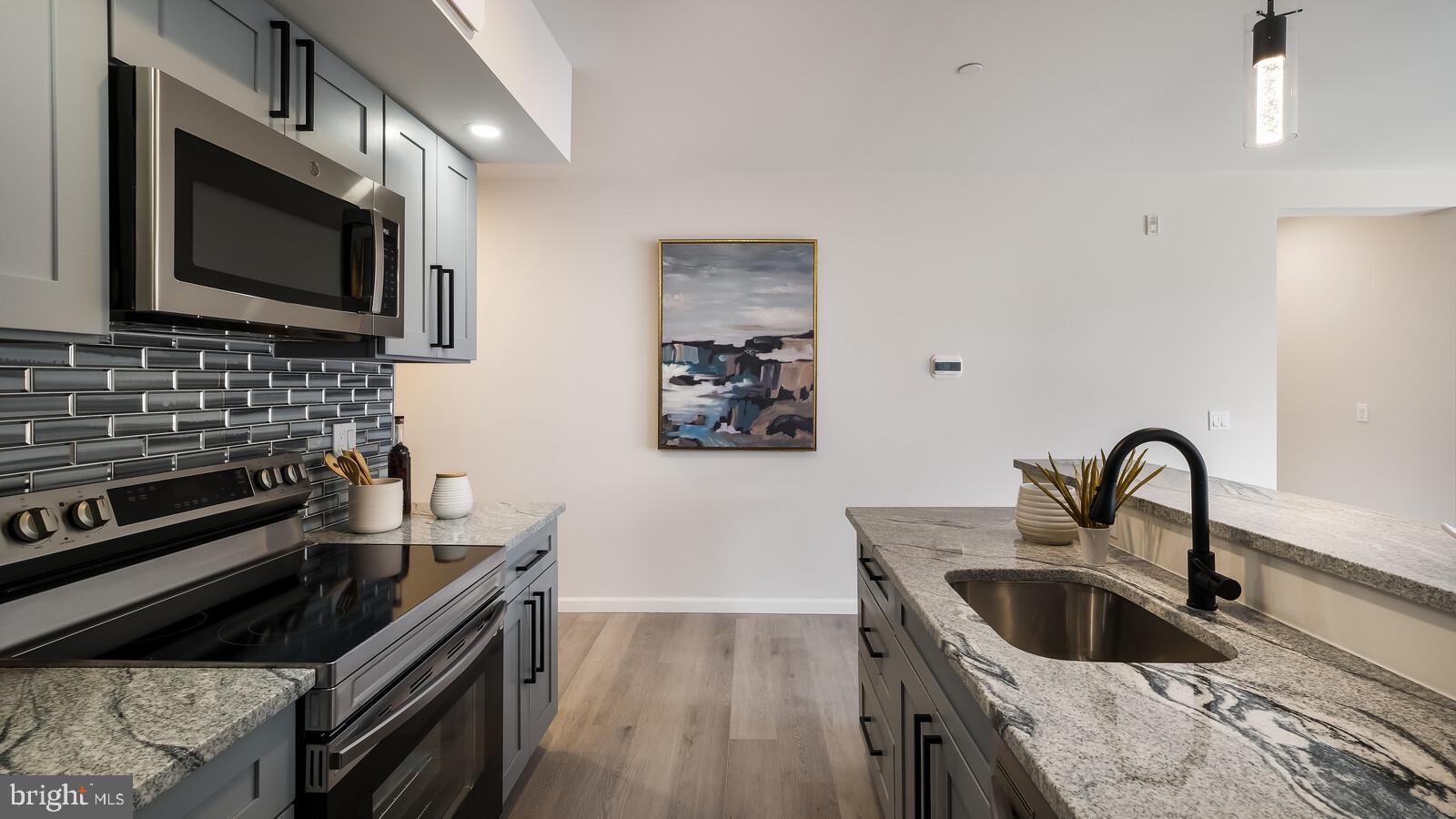 1825 Callowhill Street, Unit 311 Philadelphia, PA 19130 - Photo 6 of 50 a kitchen with a stove and a microwave