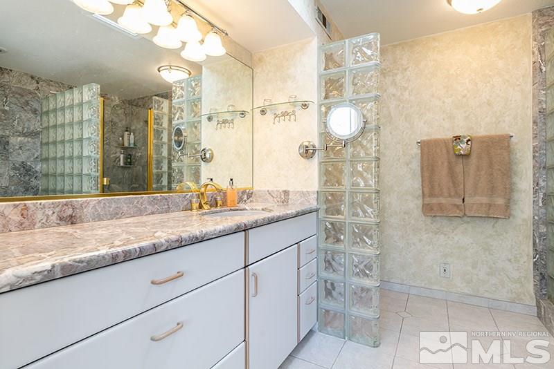 1344 Jones Street Reno, NV 89503 - Photo 16 of 24 a bathroom with a granite countertop sink a mirror and a shower