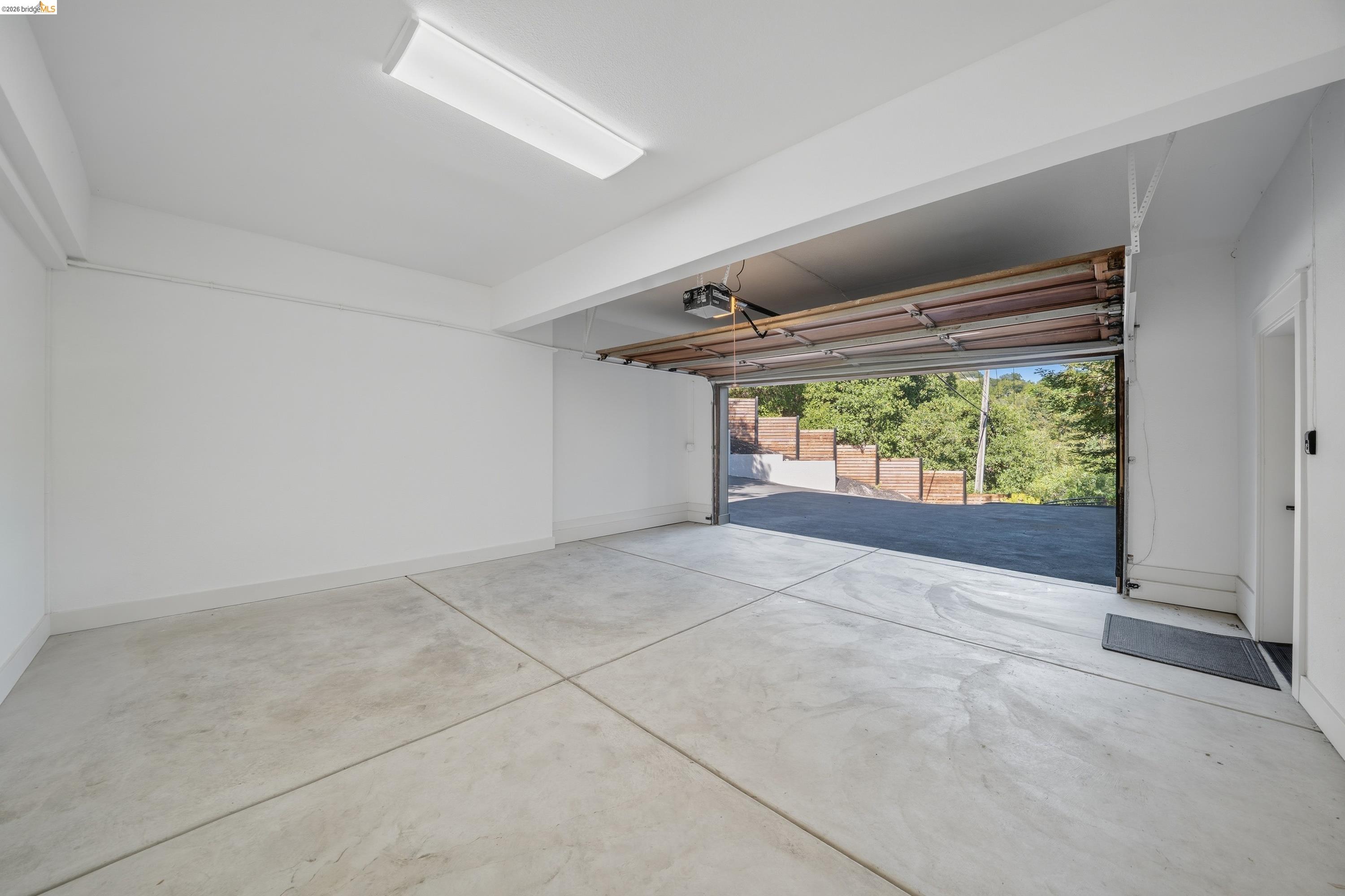 4120 Happy Valley Road Lafayette, CA 94549 - Photo 45 of 48 Spacious garage featuring a concrete floor, bright overhead lighting, painted white walls, and an automatic garage door opener
