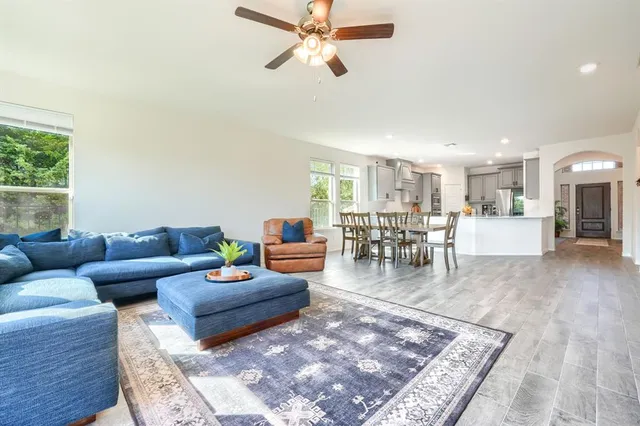 a living room with furniture and a dining table with kitchen view