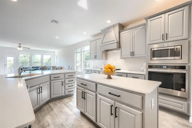 a kitchen with white cabinets and appliances