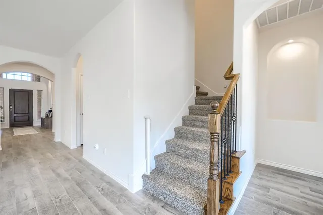 a view of a hallway with wooden floor and entryway