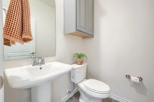 a bathroom with a sink a toilet and mirror