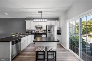 a kitchen with kitchen island granite countertop a sink and refrigerator