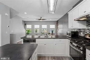 a kitchen with stainless steel appliances kitchen island granite countertop a sink stove and cabinets