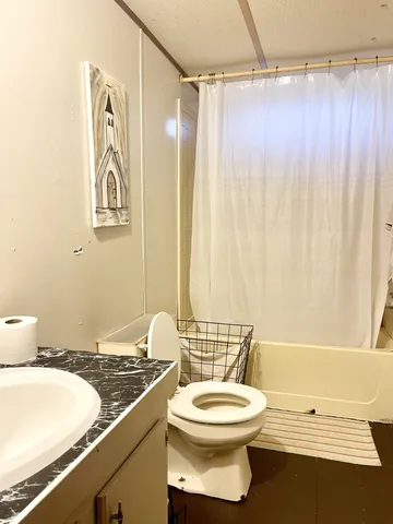 a bathroom with a granite countertop bathtub sink vanity mirror and toilet