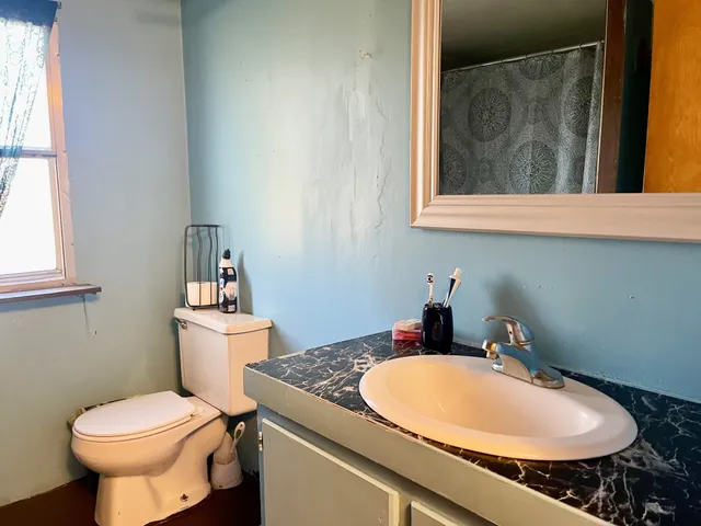 a bathroom with a granite countertop sink and a mirror