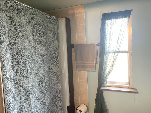 a bathroom with a window and a shower