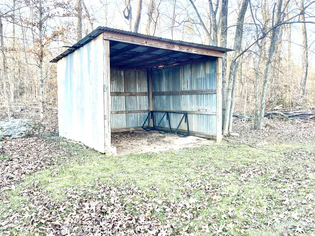 a backyard of a house with wooden fence and large trees