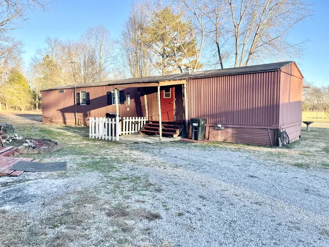 a view of a house with a yard and wooden fence