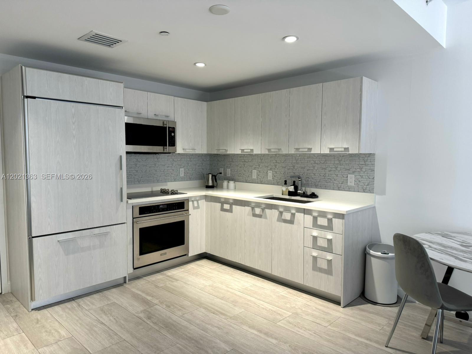 45 Southwest 9th Street, Unit 3107 Miami, FL 33130 - Photo 3 of 12 a kitchen with stainless steel appliances granite countertop a refrigerator stove a sink and a microwave