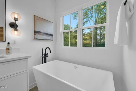 a view of an empty room with closet and a bathroom