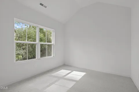 a view of a house with a big yard and large trees